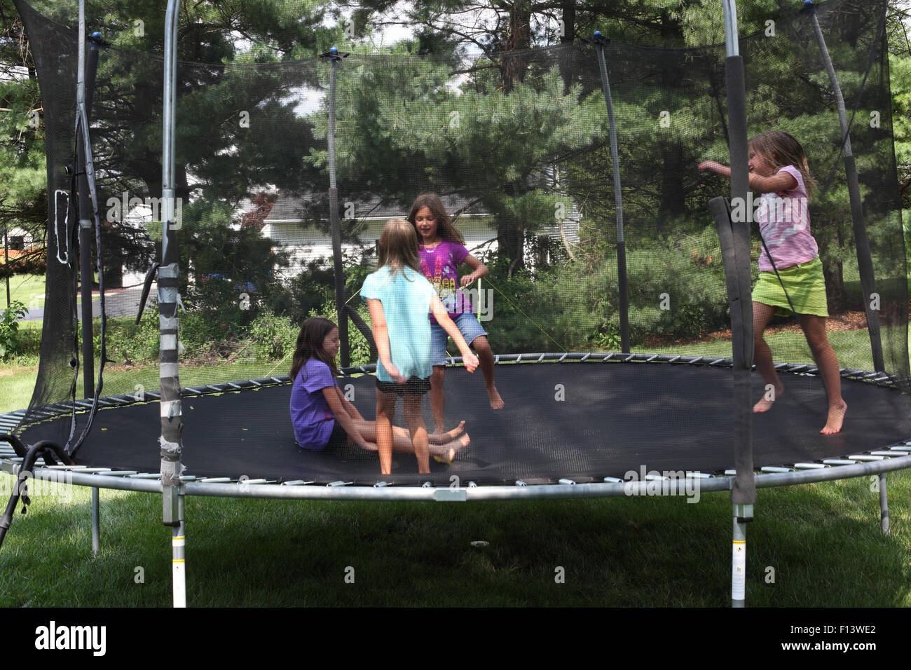 Four girls jumping on trampoline Stock Photo