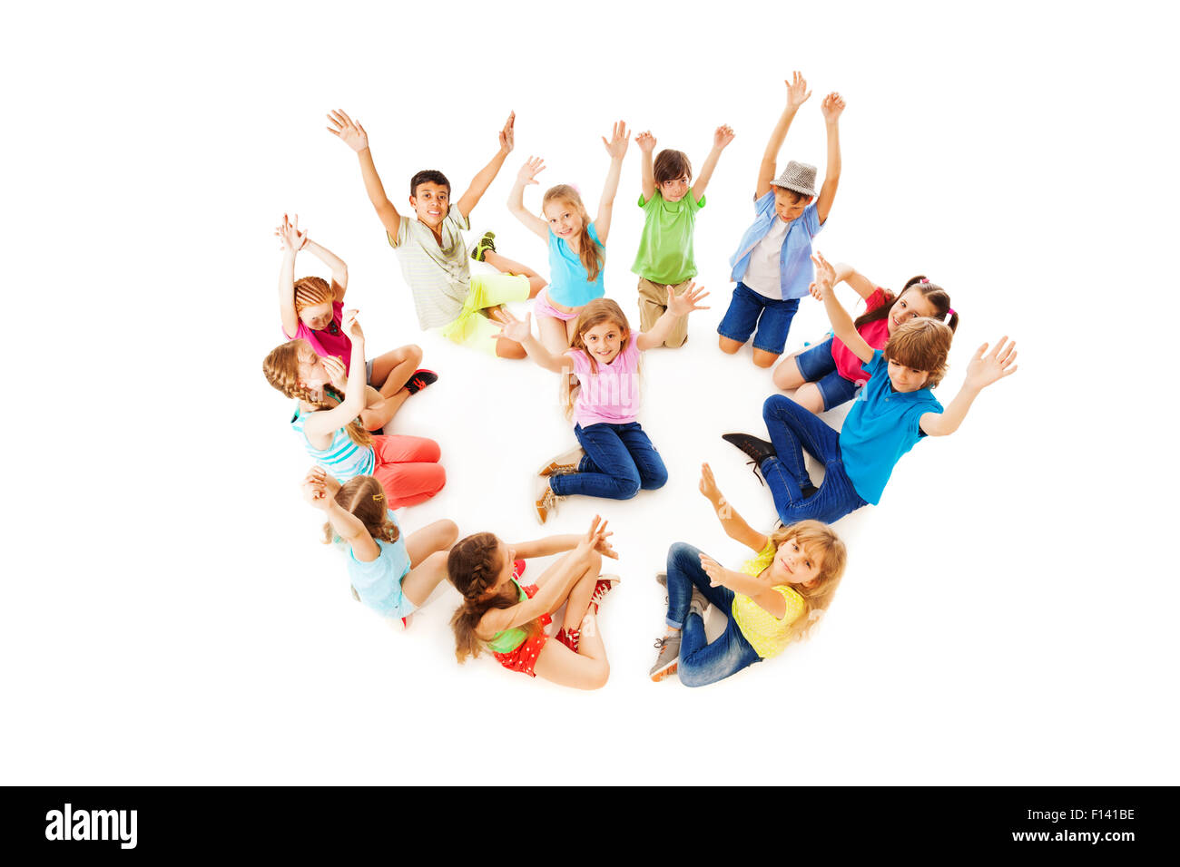 Many children in circle with boy center lift hands Stock Photo