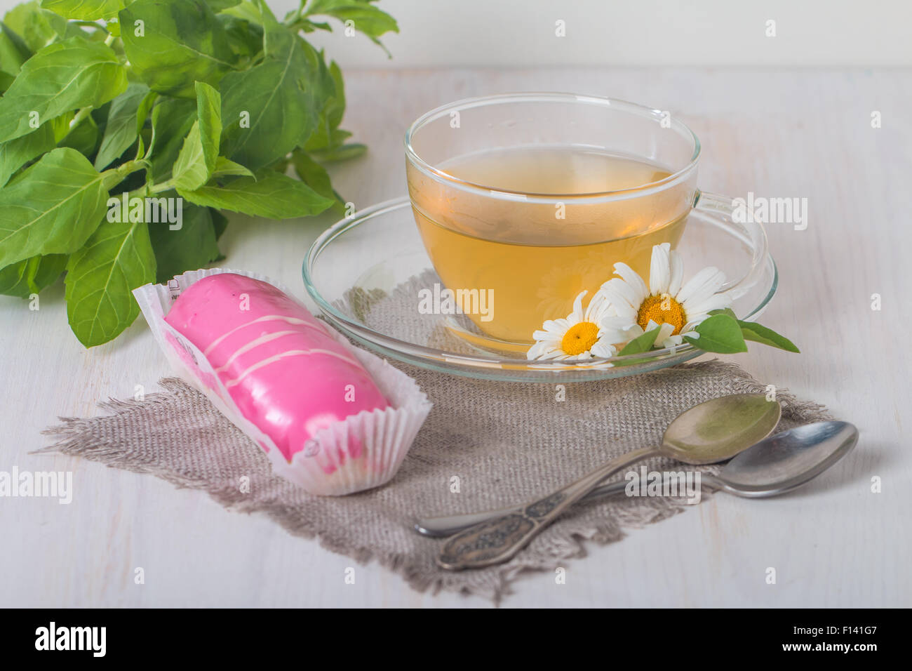 cup of chamomile tea with pink eclair on white background Stock Photo ...