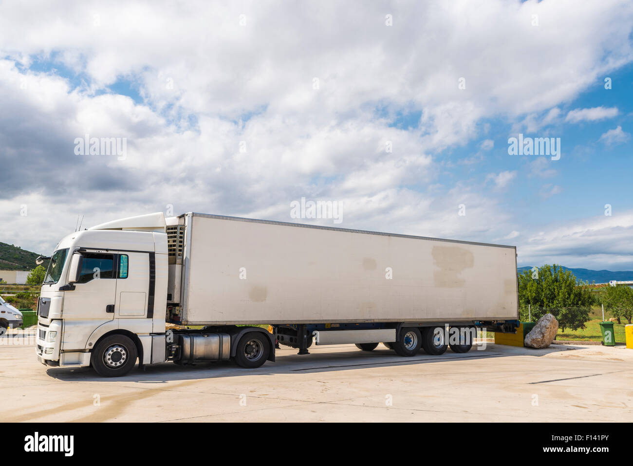 White truck equipped with refrigeration goods parked at a gas station in Spain Stock Photo