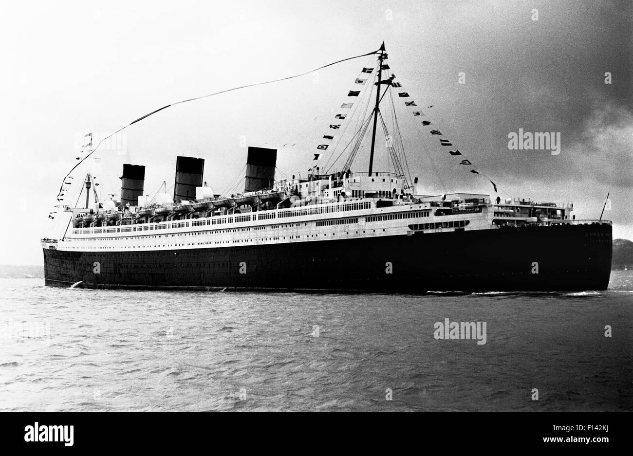 AJAXNETPHOTO. 31ST OCTOBER, 1967. SOLENT, ENGLAND. - FINAL VOYAGE - CUNARD TRANSATLANTIC LINER QUEEN MARY DRESSED OVERALL HEADS OUT OF THE SOLENT ON HER FINAL VOYAGE TO LONG BEACH CALIFORNIA. PHOTO:JONATHAN EASTLAND/AJAX REF:311067_1 Stock Photo