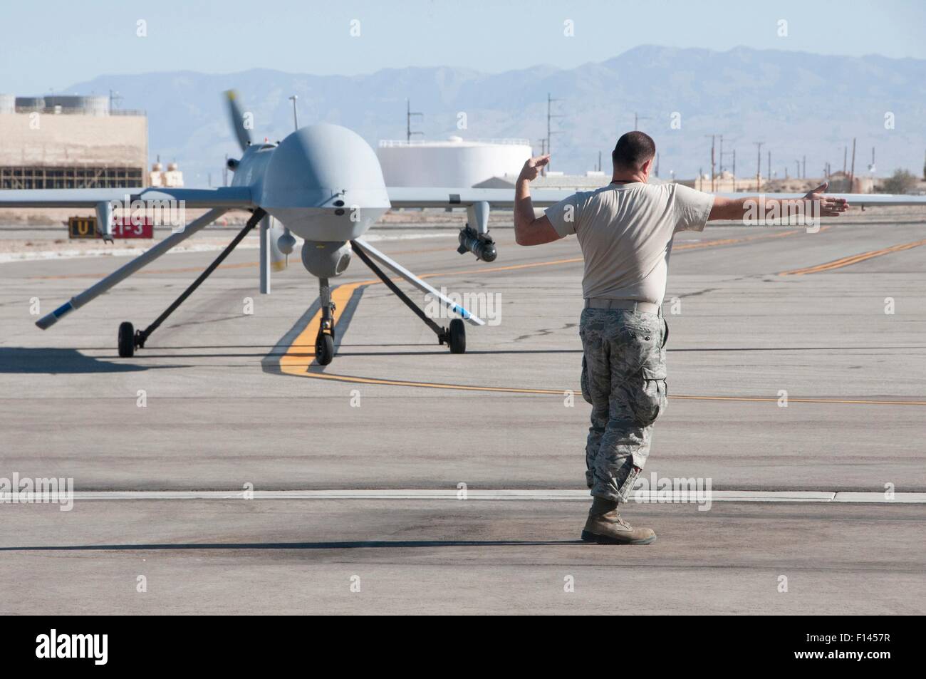 US Air Force MQ-1 Predator unmanned aerial vehicle assigned to the California Air National Guard's 163rd Reconnaissance Wing is marshaled to parking on the apron after landing at Southern California Logistics Airport November 3, 2012 in Victorville, CA. Stock Photo