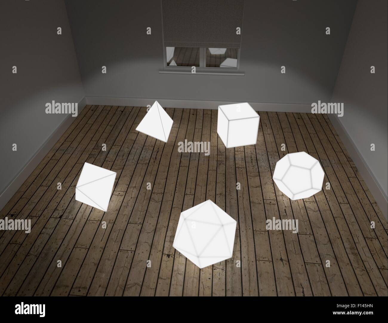 Illuminated models of the five Platonic solids on floor of room in studio Stock Photo