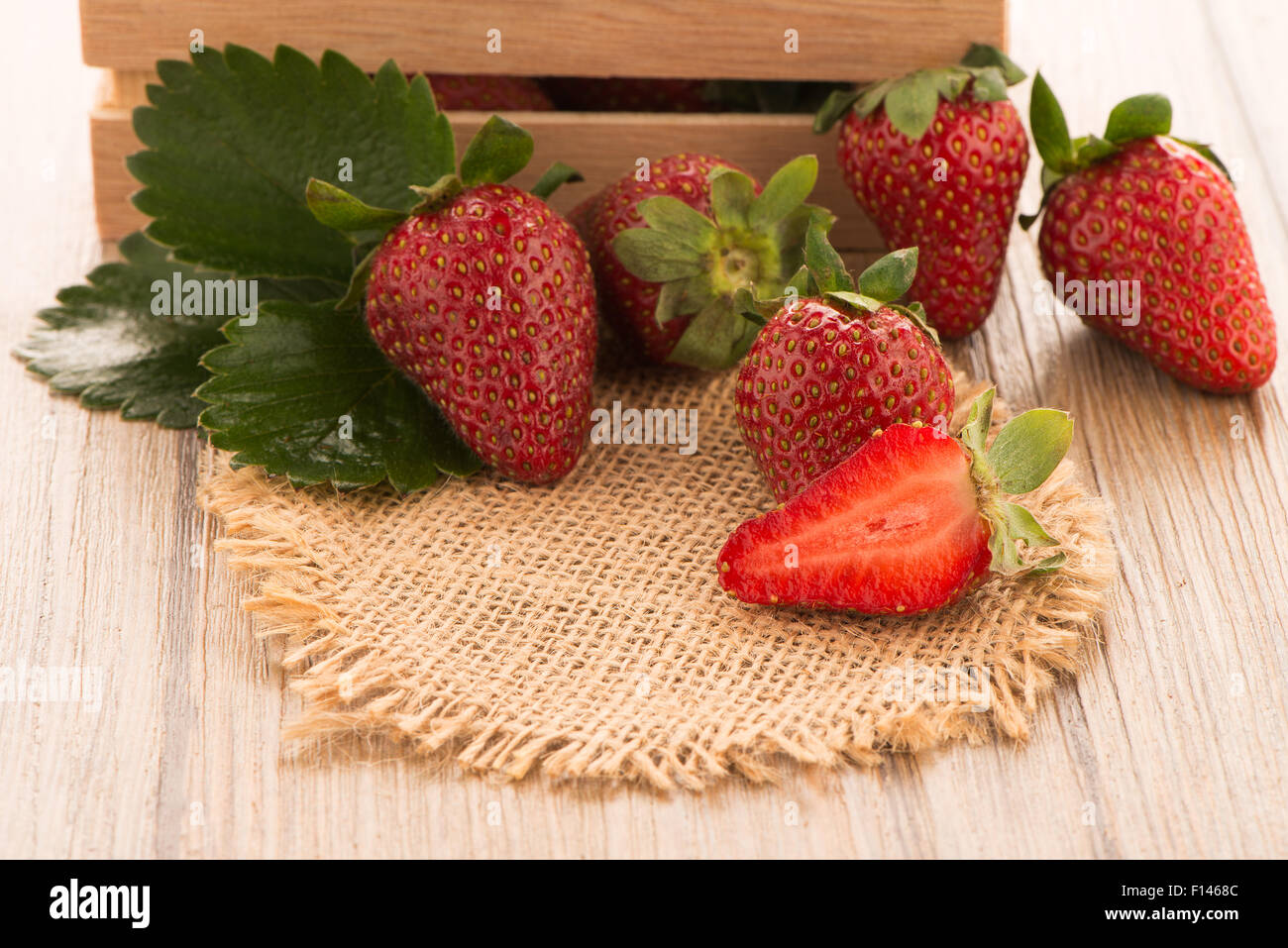 Strawberries over odl brown wooden table background Stock Photo - Alamy