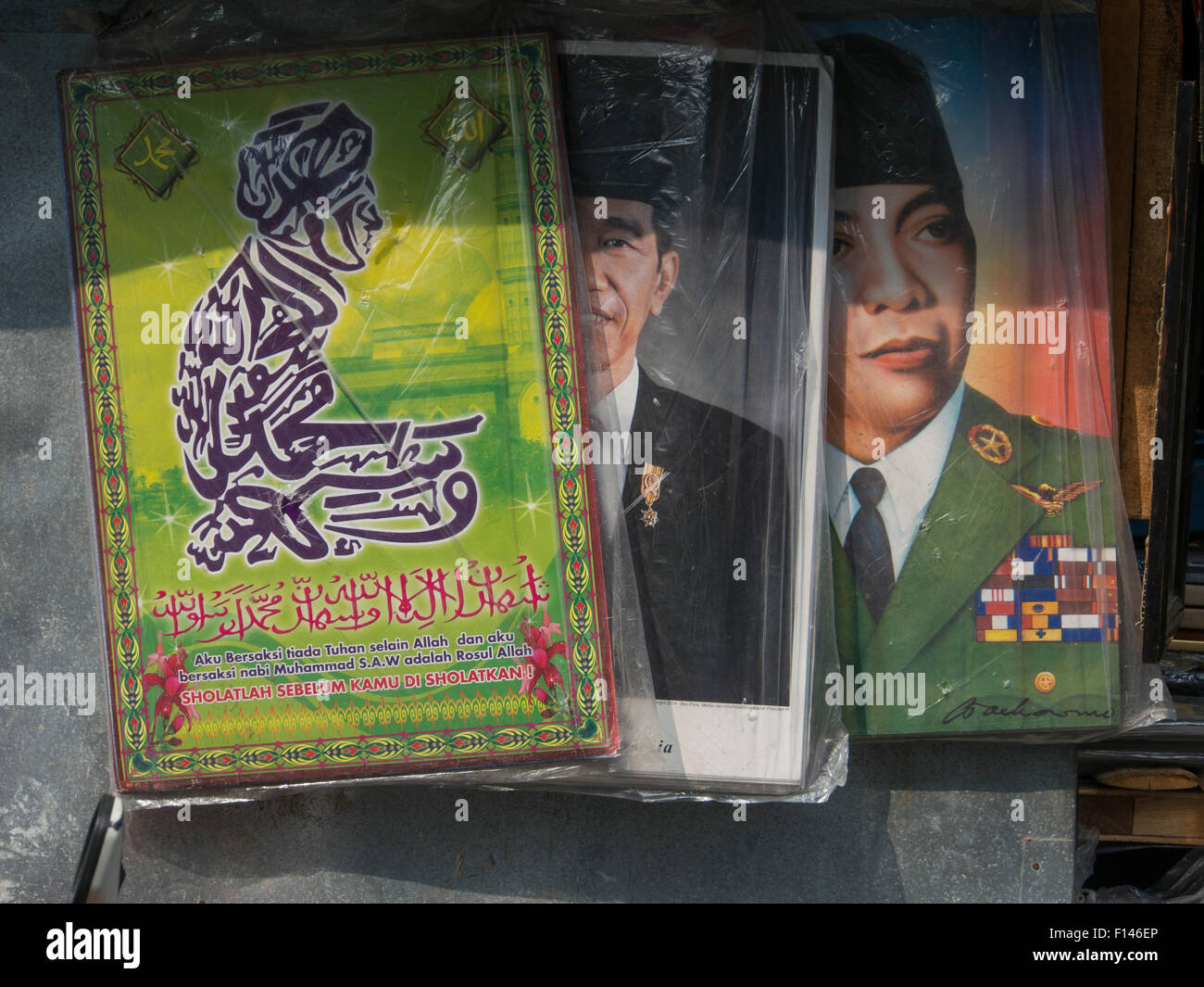 Posters of President Widodo, late president Soekarno and Muslim writings on a wall in Jakarta, Indonesia Stock Photo
