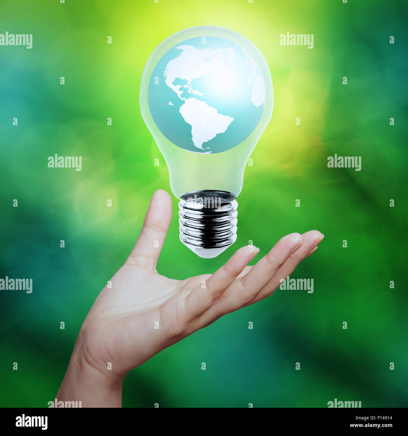 hand holding planet earth in a lightbulb as energy concept Stock Photo