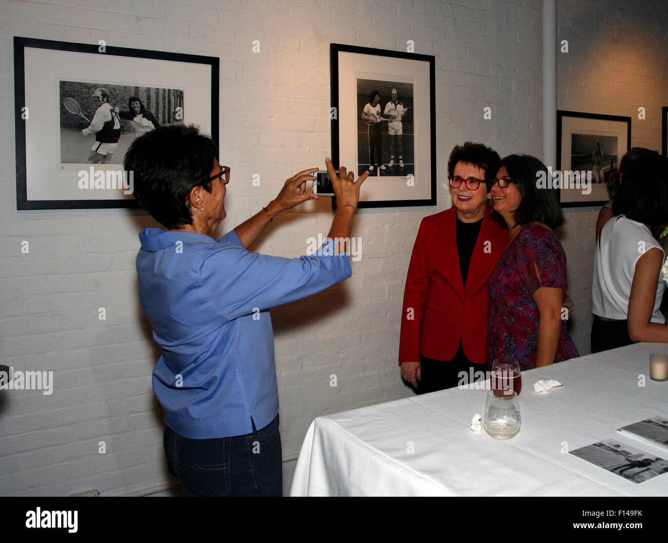 New York, USA. 26th August, 2015. Tennis legend Billie Jean King poses for a photo taken by partner during a reception at New York's Morrison Hotel Gallery in Soho on August 27th, 2015. The event sponsored by Citibank was to promote a show and book by O'Neil who photographed King and other celebrities extensively in the 1970's and 80's.  On the wall above King are images of her with rock star Elton John which were taken by O'Neil. Credit:  Adam Stoltman/Alamy Live News Stock Photo