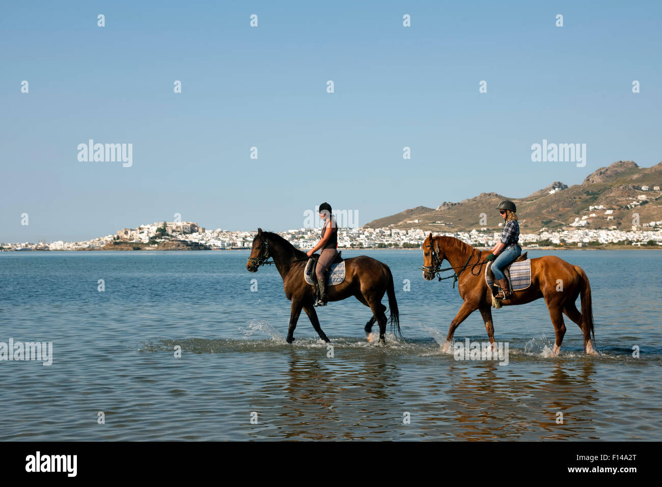 Griechenland, Kykladen, Naxos, Reiter am Strand bei Agios Prokopios. Veranstalter der Reitausflüge Iris Neubauer. im Hintergrund Stock Photo