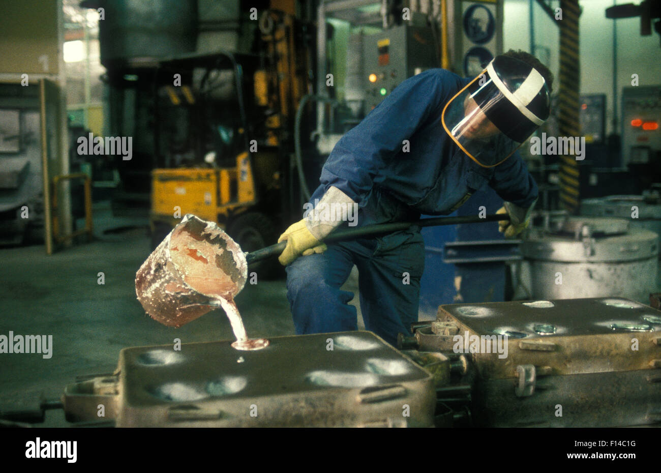 Foundry worker pouring molten aluminium into casting molds at the Maranello Ferrari factory Stock Photo