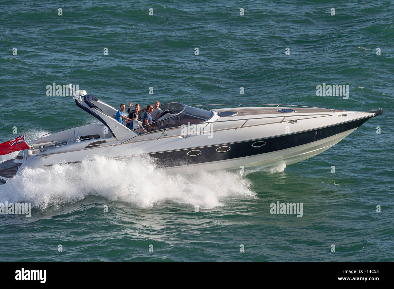 Men enjoying a powerful boat ride in the Solent off Southampton. Stock Photo