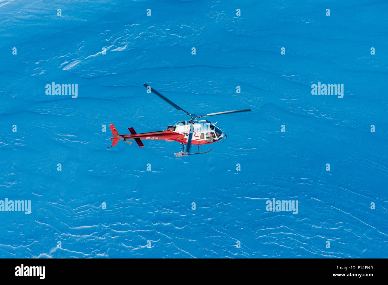 Helicopter in flight in front of a wall of snow, Swiss Alps, Engadin, Canton of Graubünden, Switzerland Stock Photo