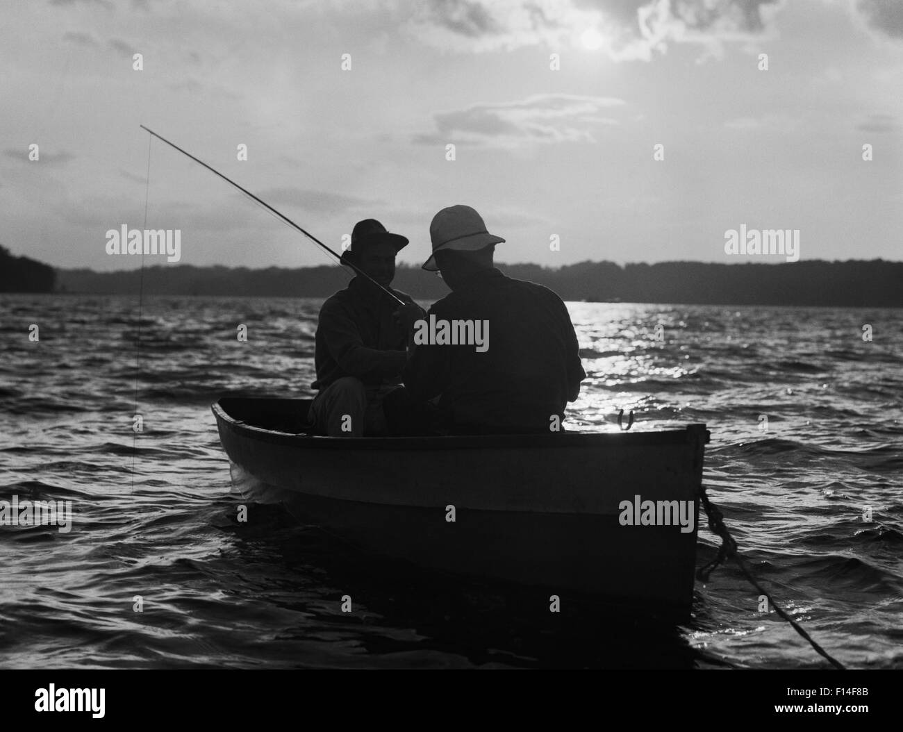 Two men fishing at sunrise Black and White Stock Photos & Images - Alamy