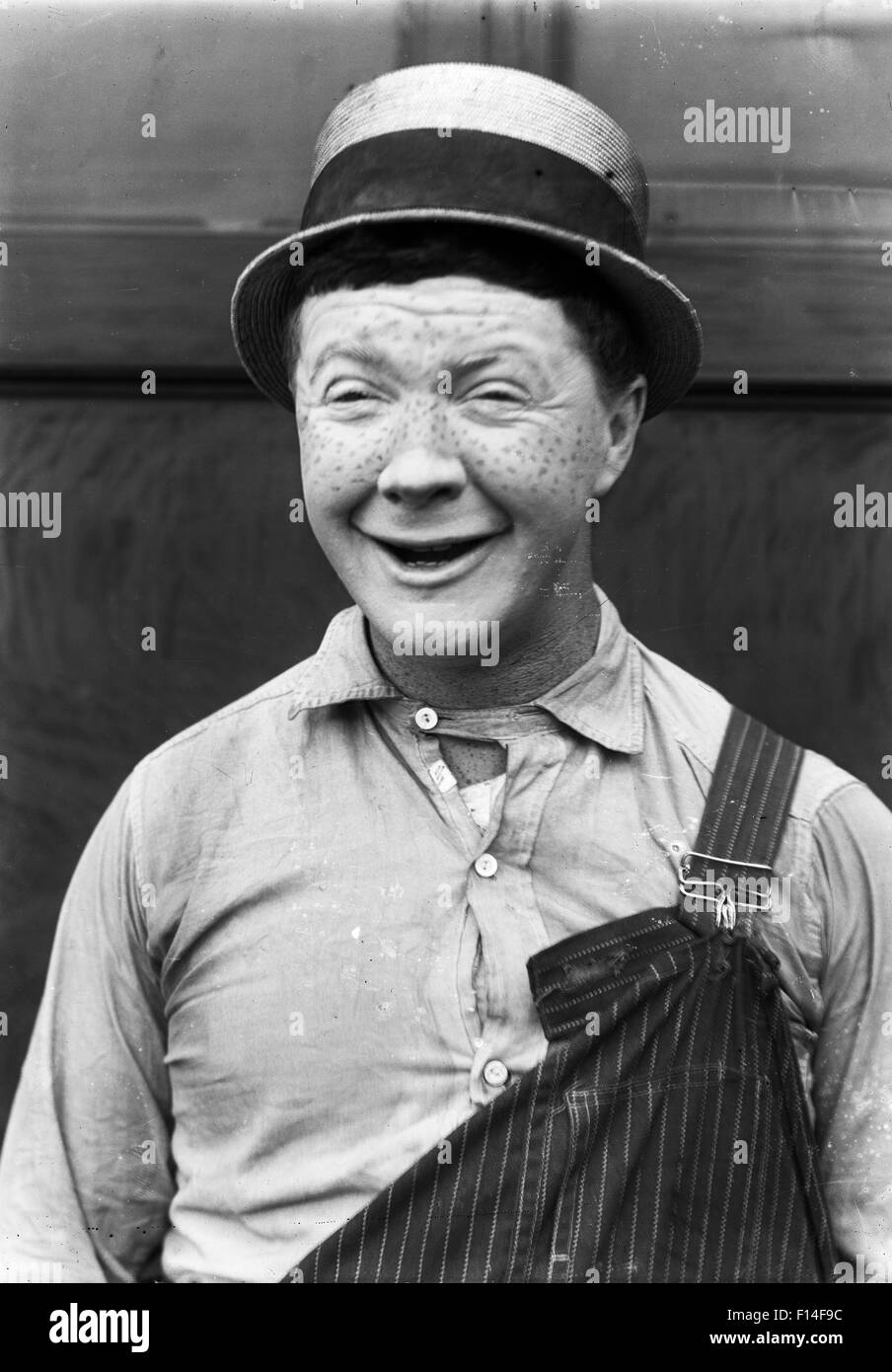1910s 1920s MAN MOVIE ACTOR COMEDIAN STANDING SMILING WITH HUMOROUS FACIAL EXPRESSION SILENT MOVIE STILL Stock Photo