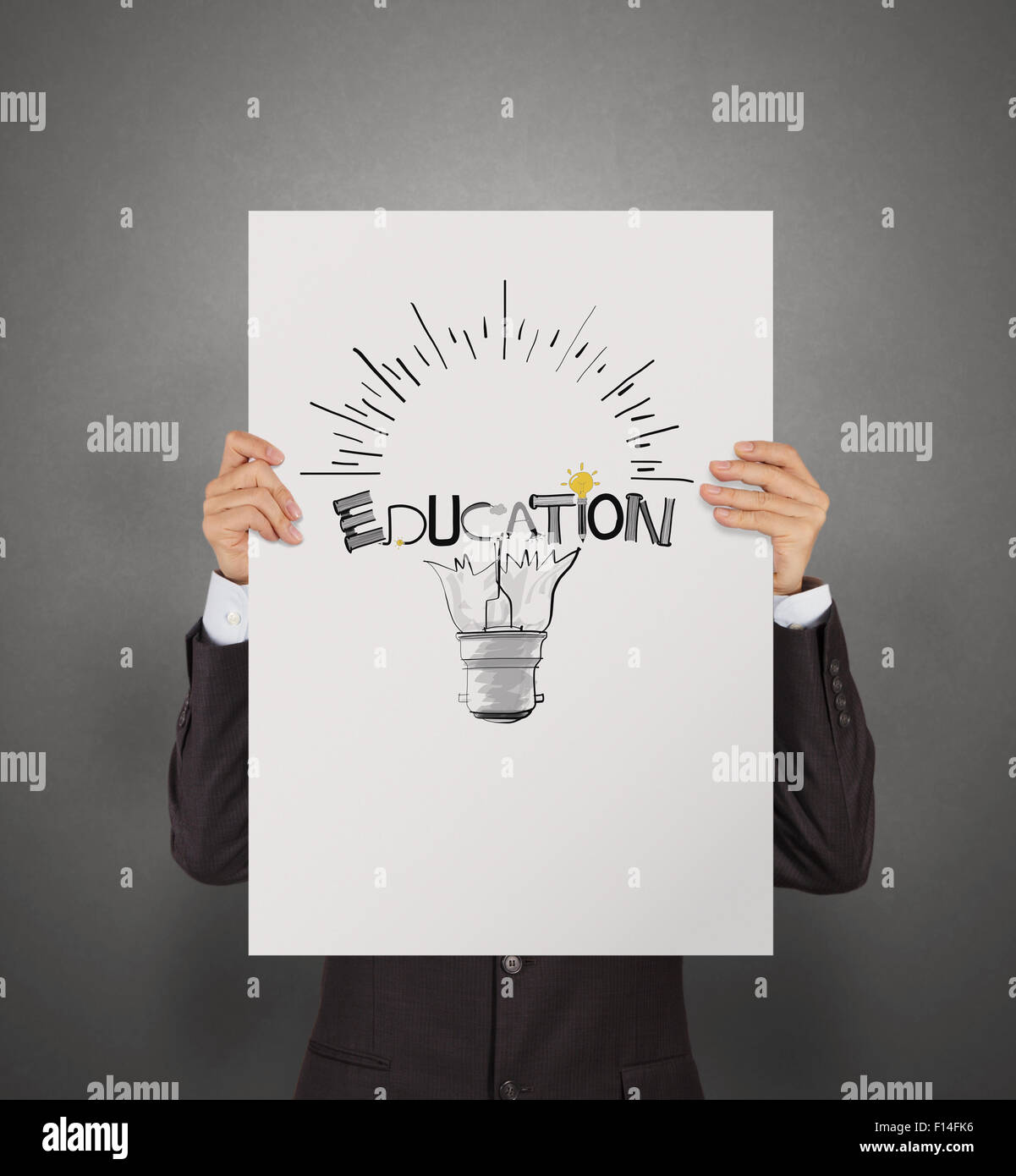 business man showing hand drawn graphic design EDUCATION word  and light bulb on poster board  as concept Stock Photo