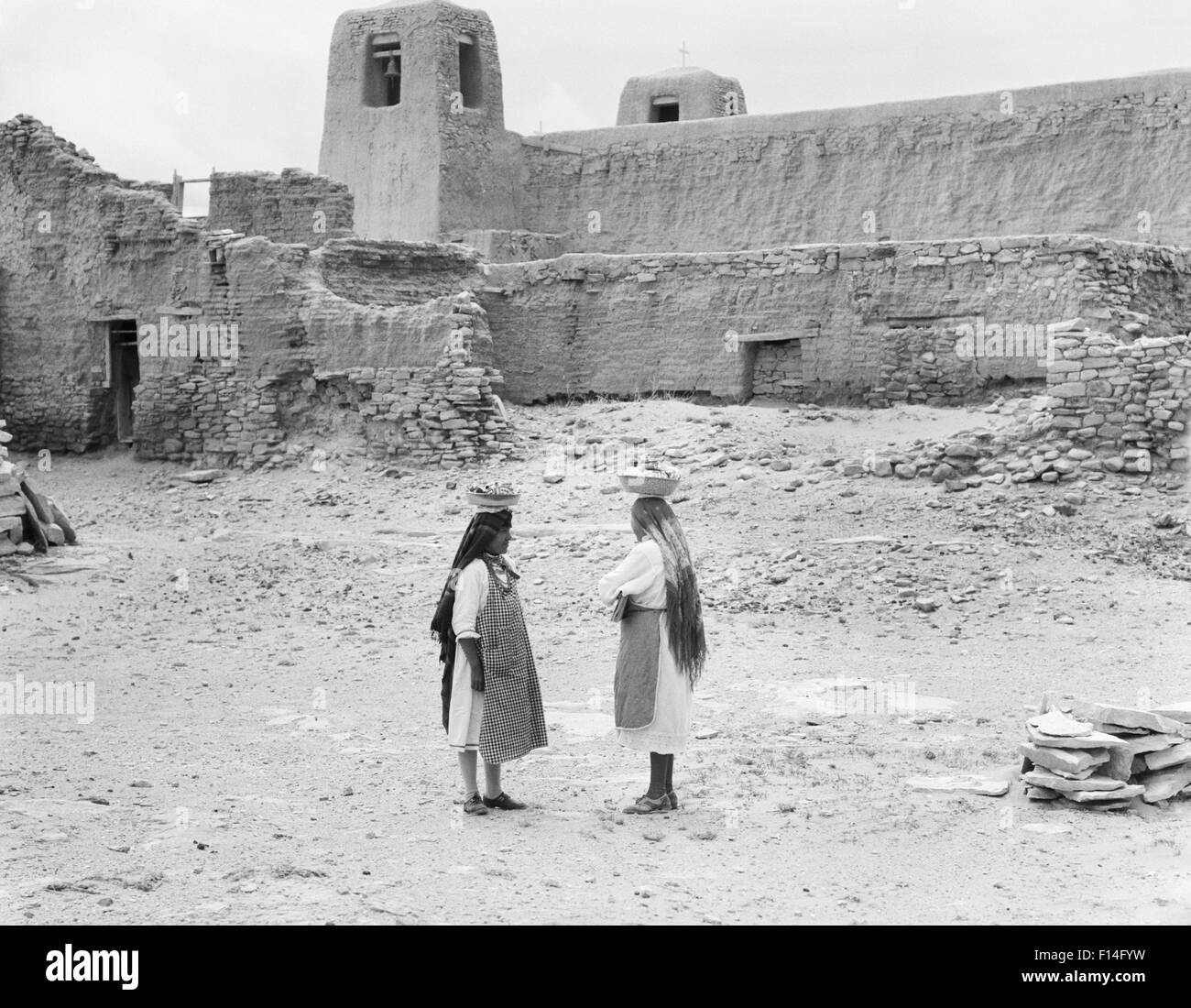 1930s TWO NATIVE AMERICAN WOMEN IN SKY CITY THE OLDEST CONTINUOUSLY INHABITED CITY IN NORTH AMERICA ACOMA PUEBLO NEW MEXICO USA Stock Photo