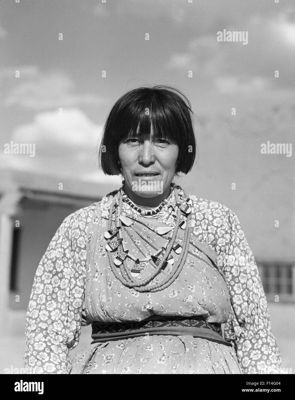 1930s PORTRAIT NATIVE AMERICAN WOMAN LOOKING AT CAMERA WEARING TYPICAL COSTUME AND JEWELRY SAN ILDEFONSO PUEBLO NEW MEXICO Stock Photo