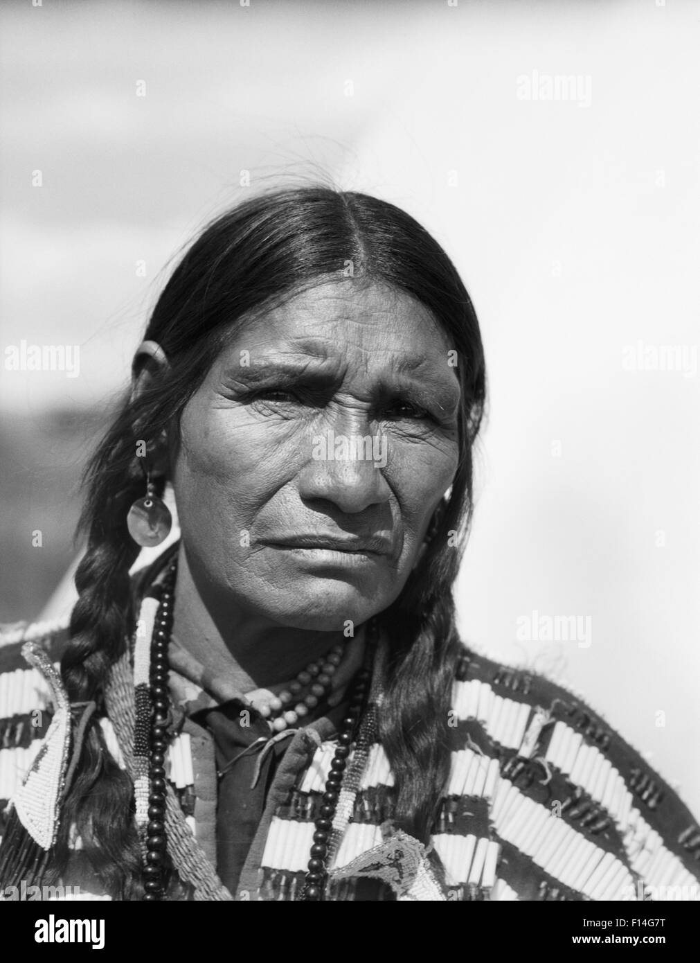 1920s PORTRAIT NATIVE AMERICAN MAN SERIOUS EXPRESSION LOOKING AT CAMERA STONEY SIOUX TRIBE ALBERTA CANADA Stock Photo