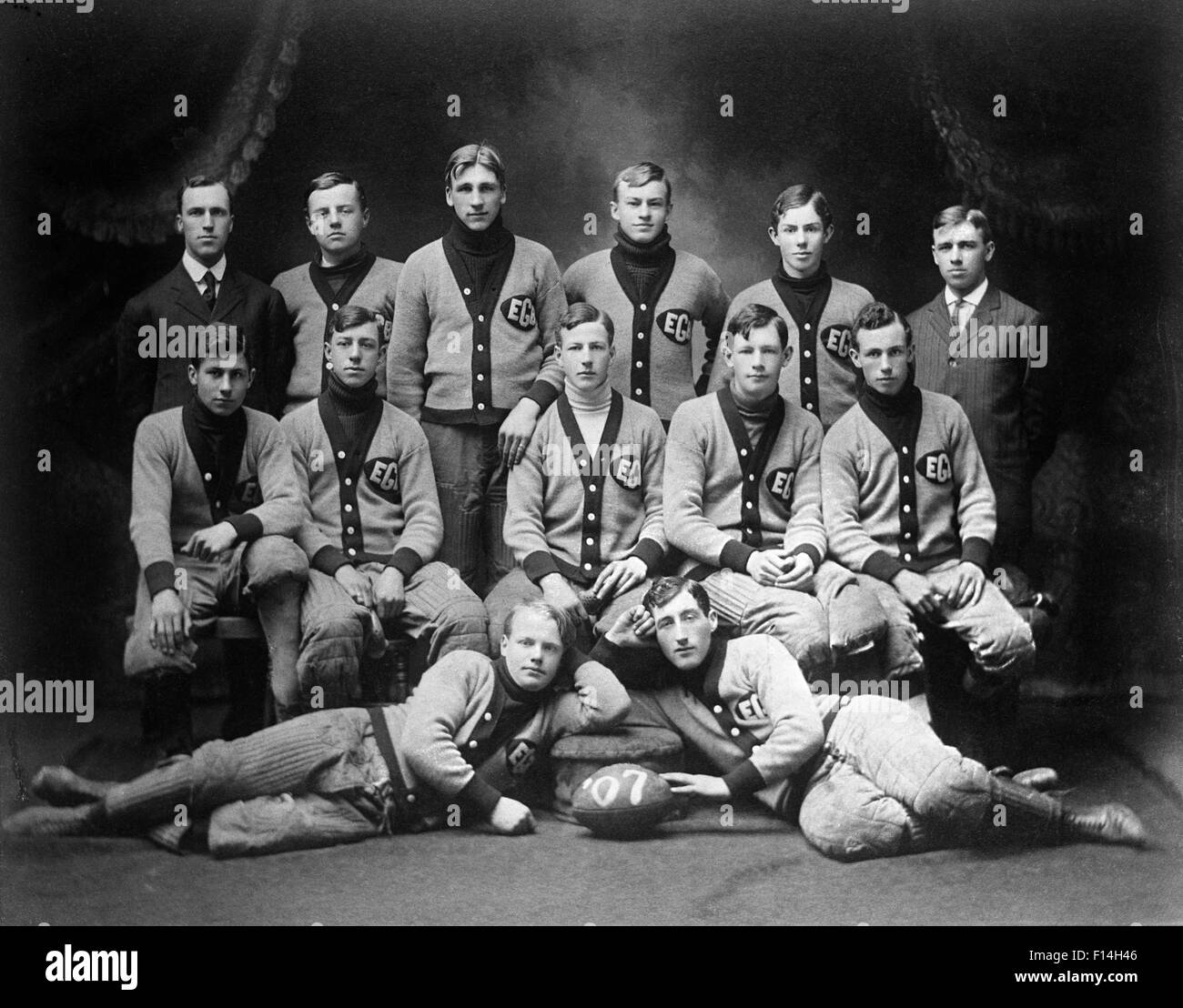 1900s 1907 GROUP PORTRAIT HIGH SCHOOL FOOTBALL TEAM PLAYERS WEARING TEAM UNIFORMS VARSITY SWEATERS Stock Photo