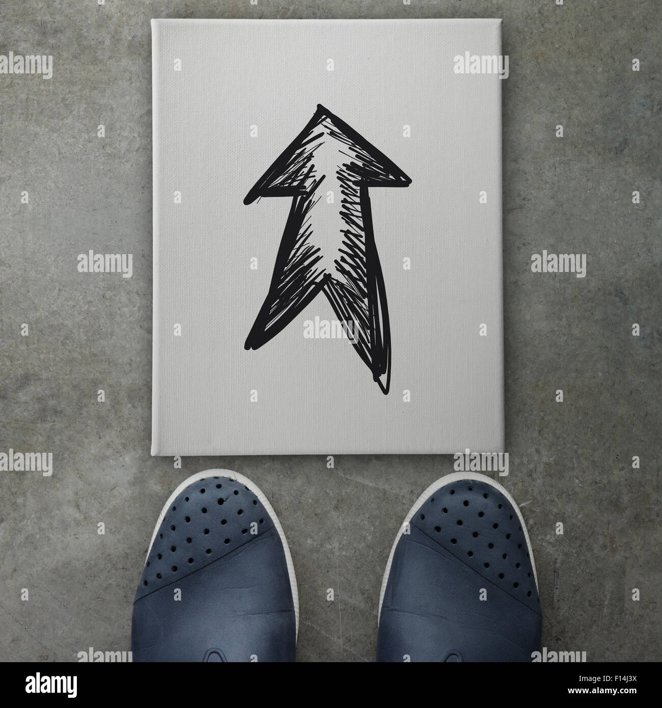 Hand drawn arrow design doodle icon on front of business man feet as concept Stock Photo