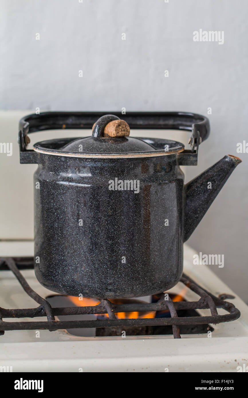 Old kettle on a gas stove flame burn not boiling Stock Photo Alamy