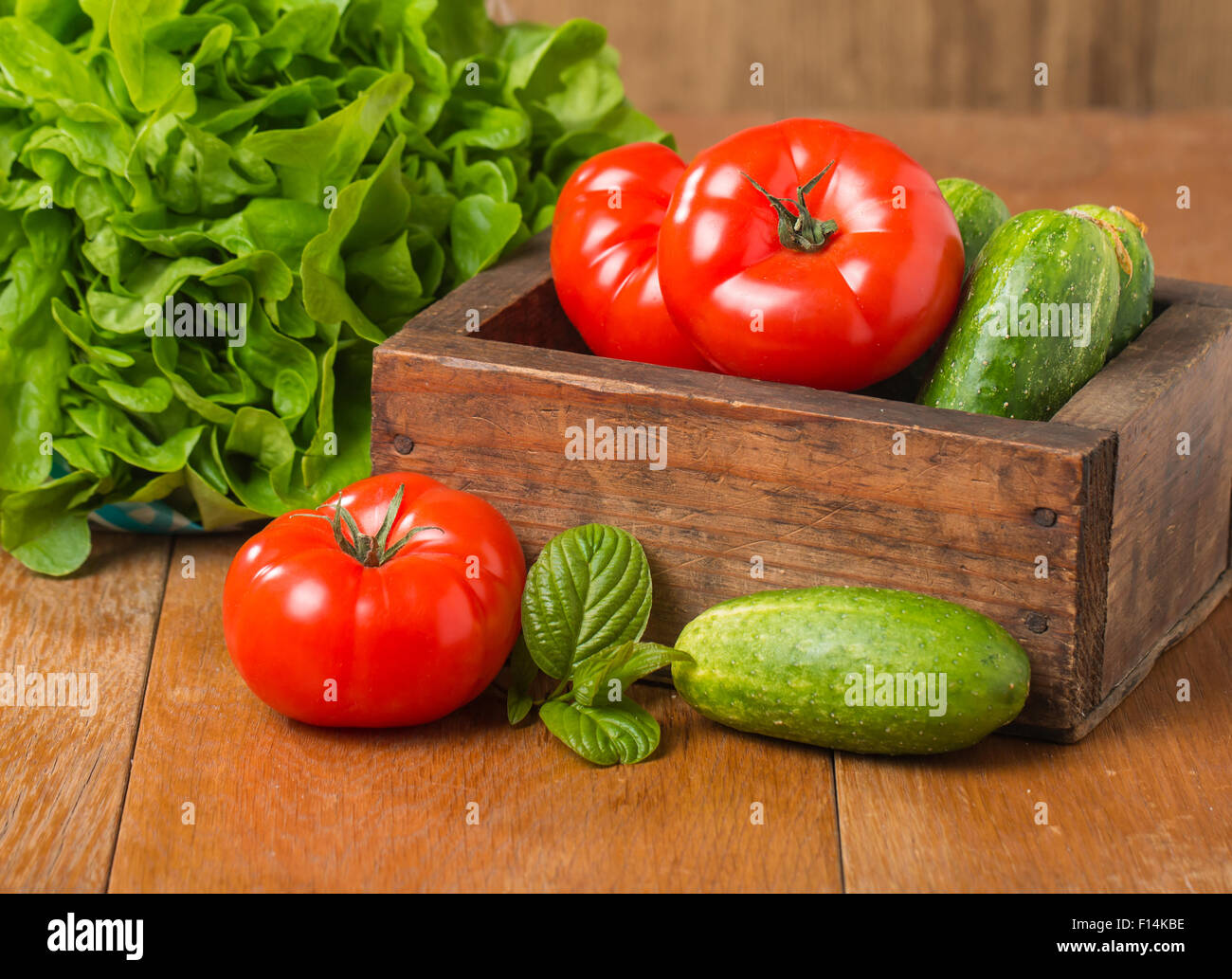 Arrangement of Raw Cucumbers, Tomatoes and Butterhead Lettuce in Wooden