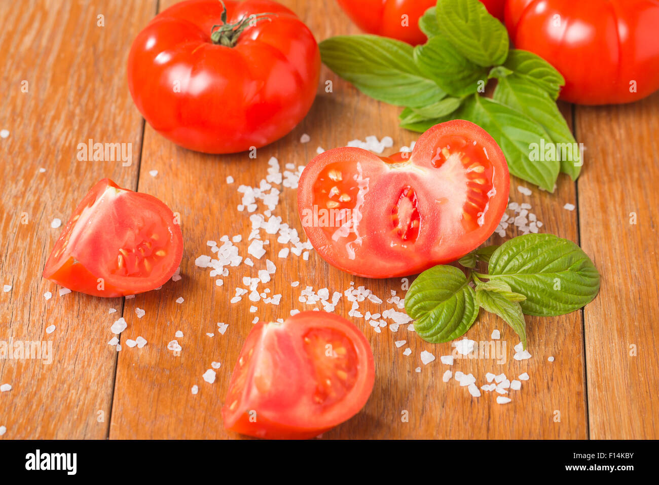 Fresh tomatoes with salt on wooden table Stock Photo - Alamy