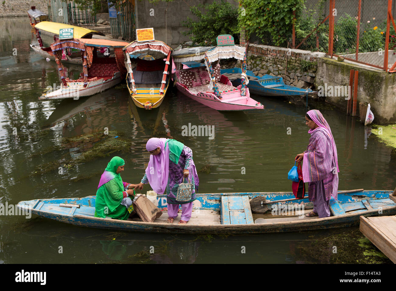 India, Jammu & Kashmir, Srinagar, Dal Lake, three colourfully dressed local women in shikara boat Stock Photo