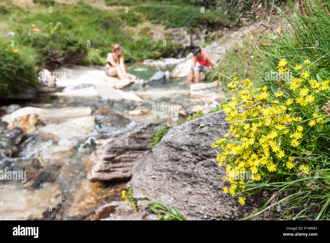 Women rest her feets in a cool water of a creek. Baveno, Piemonte. Italy Stock Photo