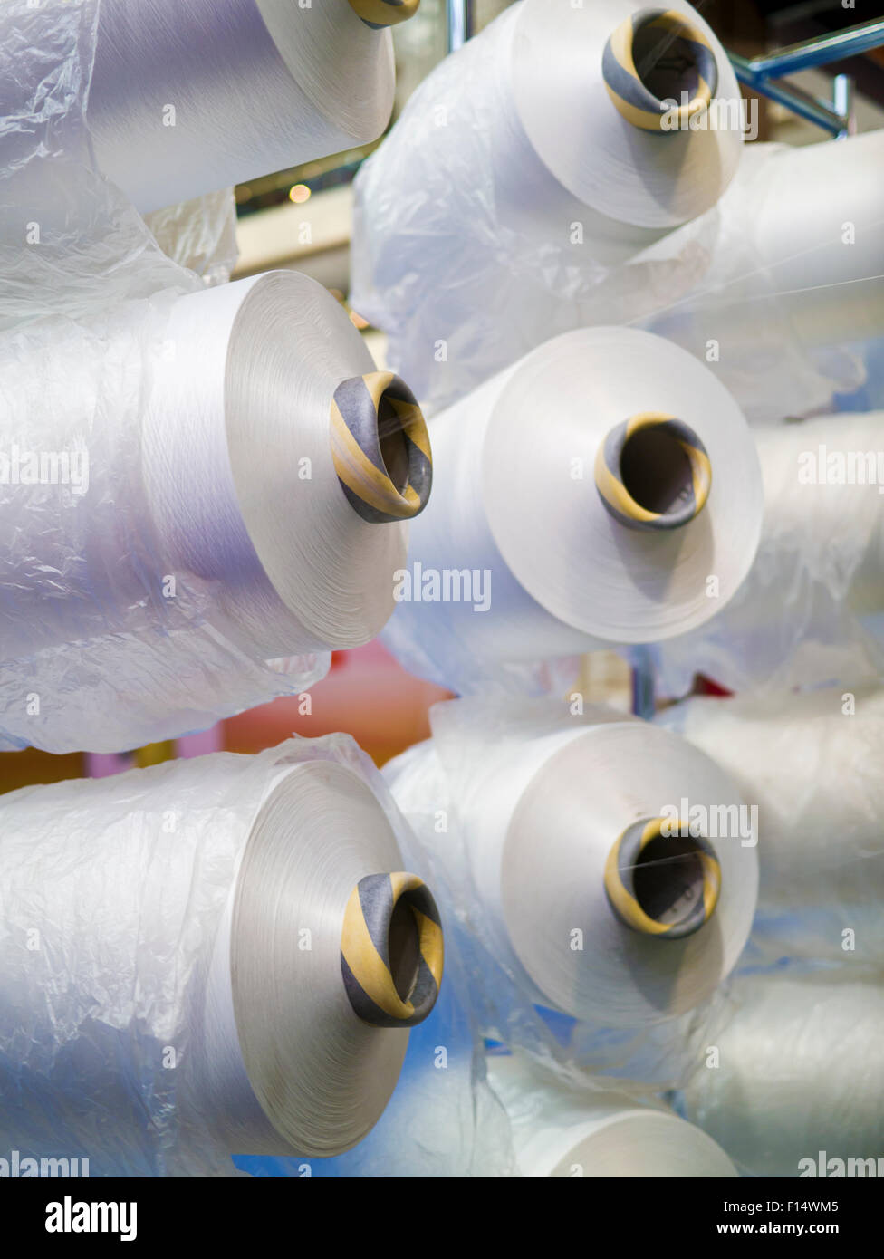 Textile industry - yarn spools on spinning machine in a textile factory Stock Photo