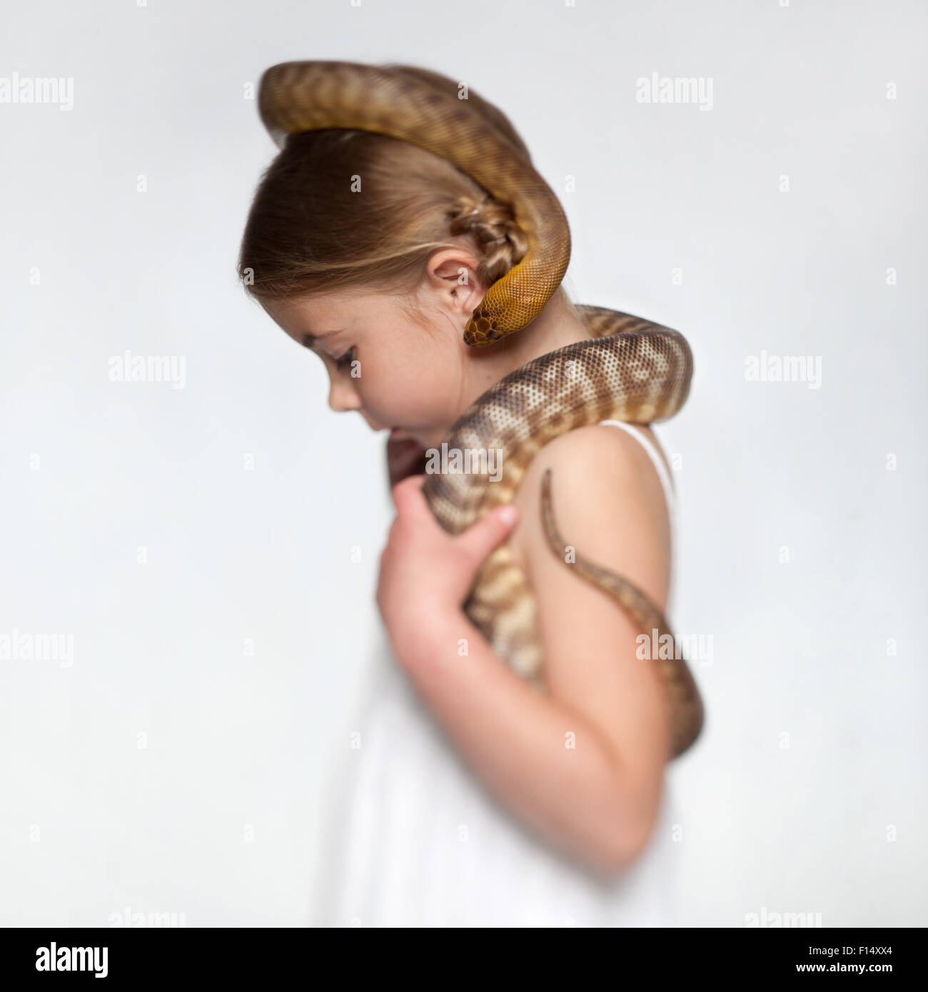 Studio portrait of girl (6-7) with snake Stock Photo