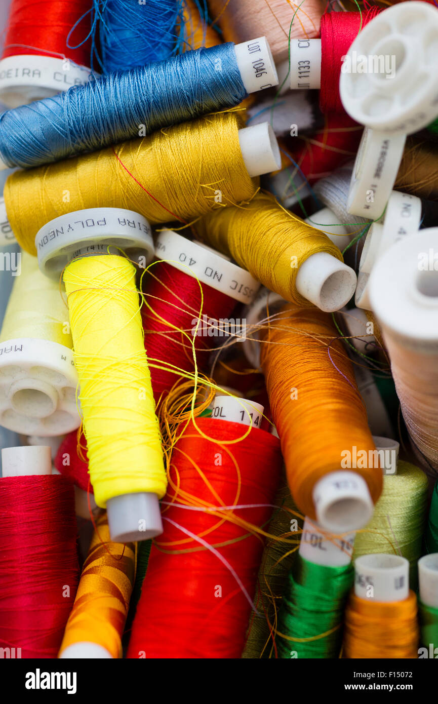 A jumble of assorted spools of coloured embroidery embroidering threads