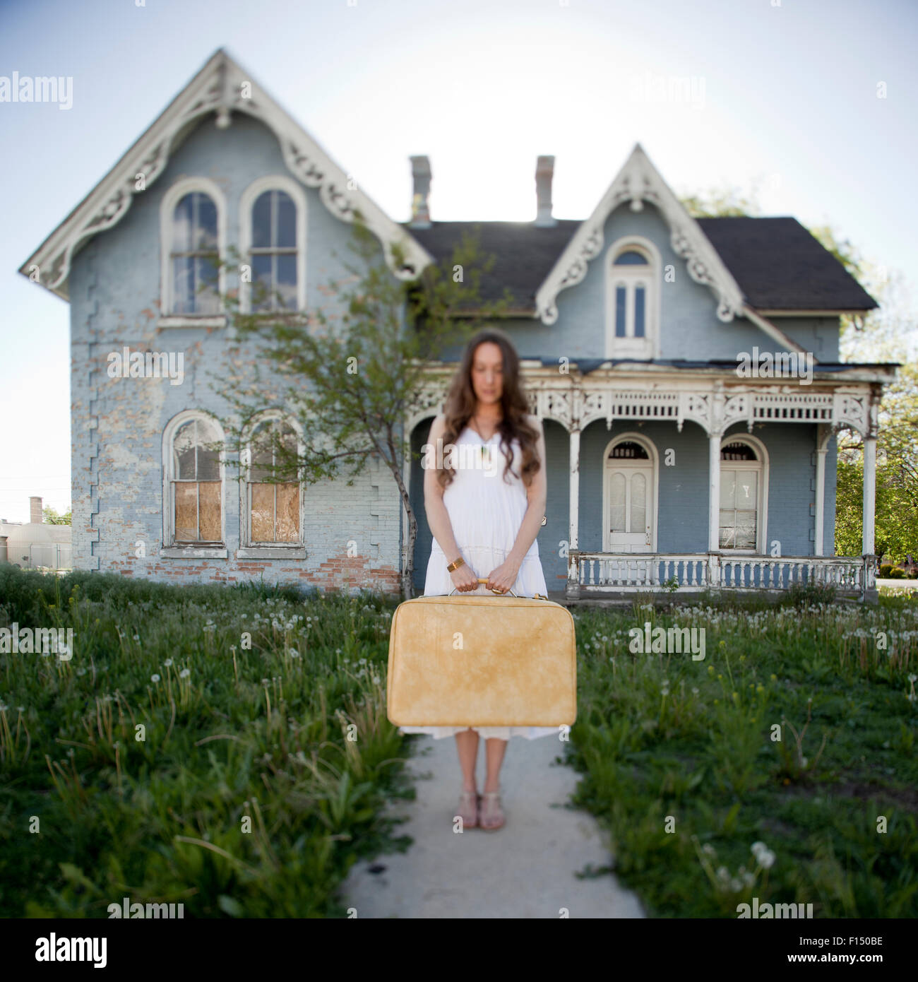 Woman front house suitcase hi-res stock photography and images - Alamy