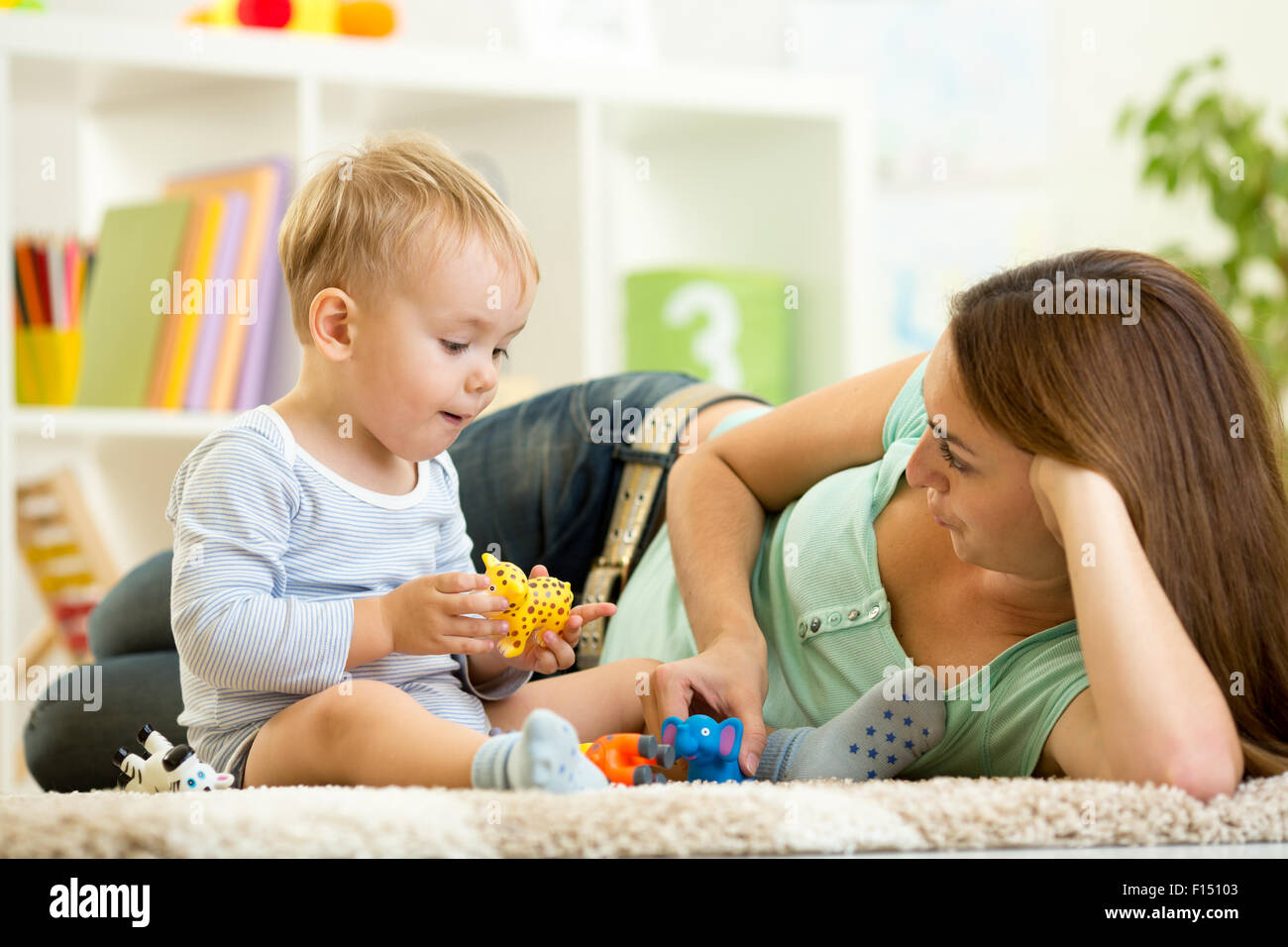 child and his mom play zoo holding animal toys Stock Photo