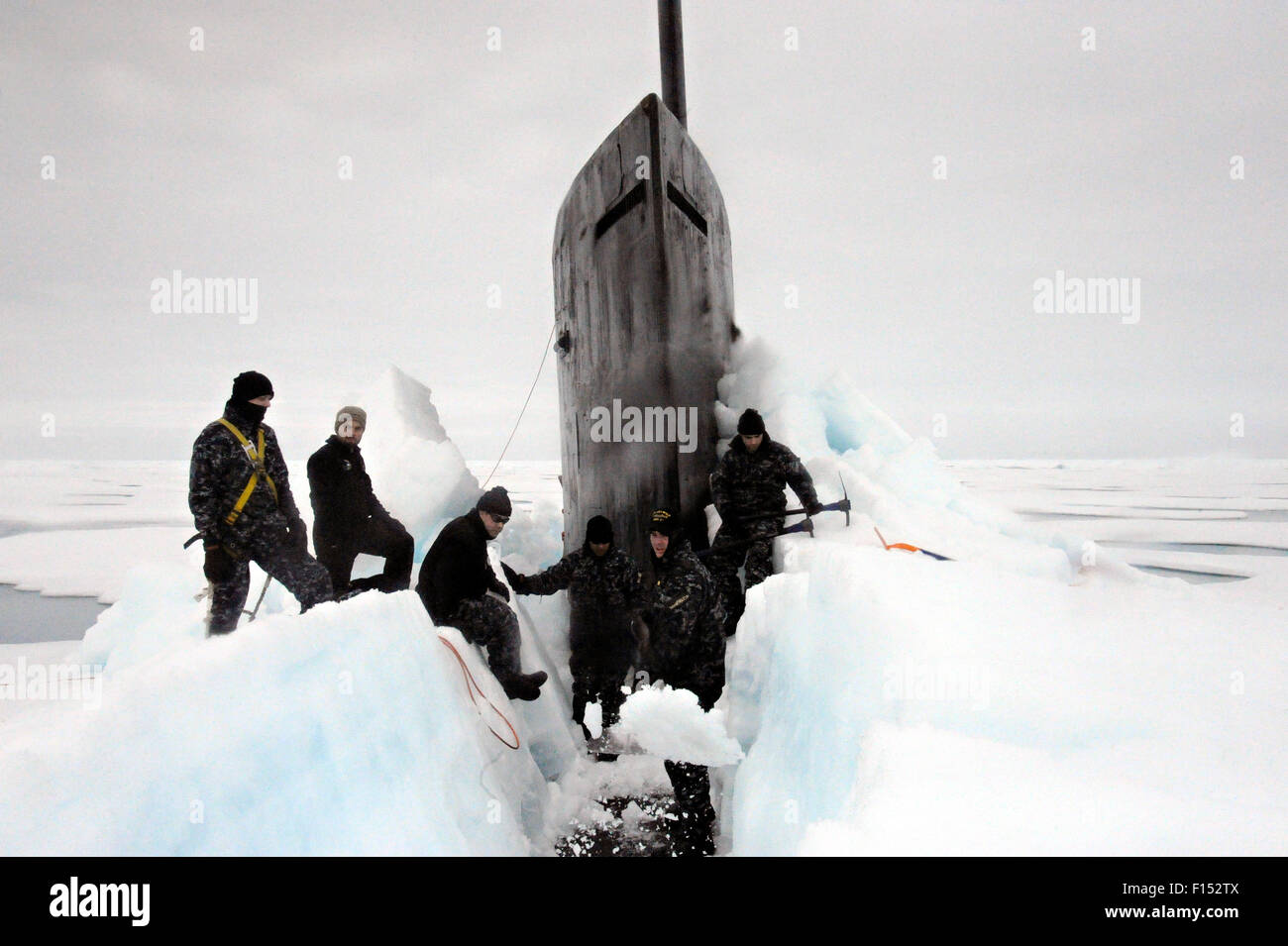 US Navy Sailors aboard the fast attack nuclear submarine USS Seawolf remove arctic ice from the hull after surfacing in the North Pole August 1, 2015. Stock Photo