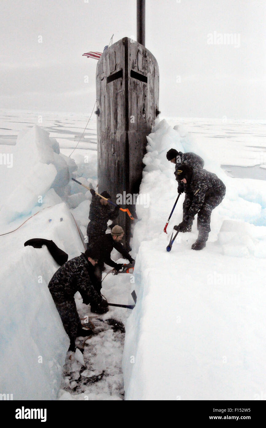 US Navy Sailors aboard the fast attack nuclear submarine USS Seawolf remove arctic ice from the hull after surfacing in the North Pole August 1, 2015. Stock Photo