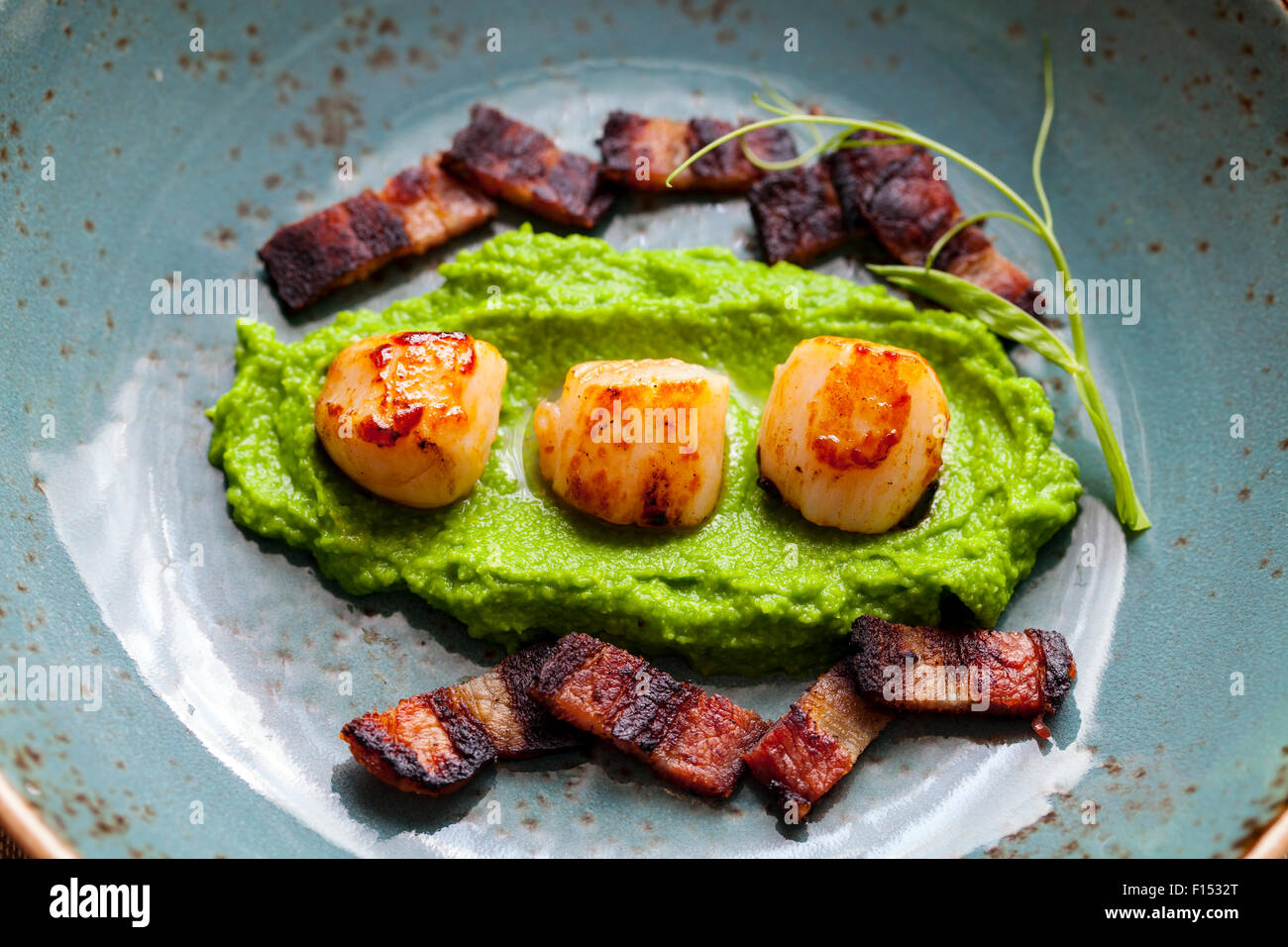 Scallops with pea puree and crispy bacon Stock Photo Alamy