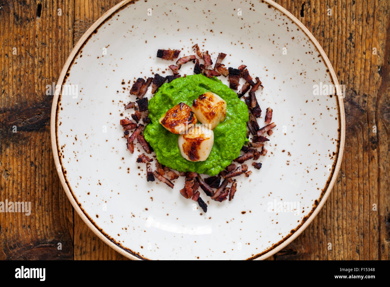 Scallops with pea puree and crispy bacon Stock Photo Alamy