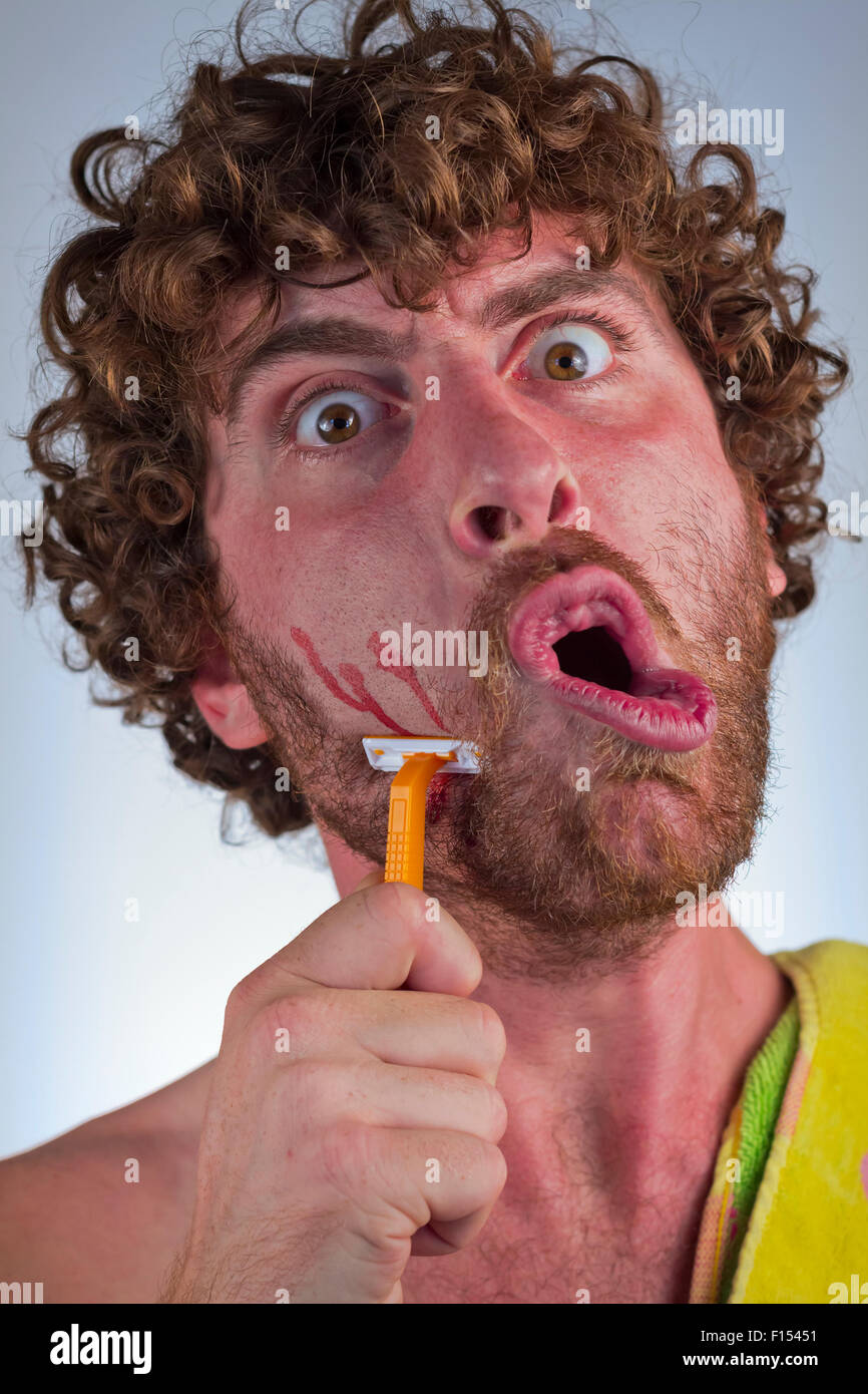 Silly bearded man cuts his face while shaving off his beard Stock Photo -  Alamy