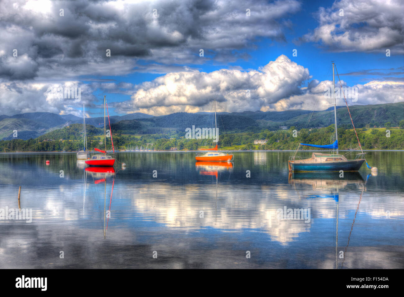 Peaceful calm lake with red orange and blue sailing boats with hills