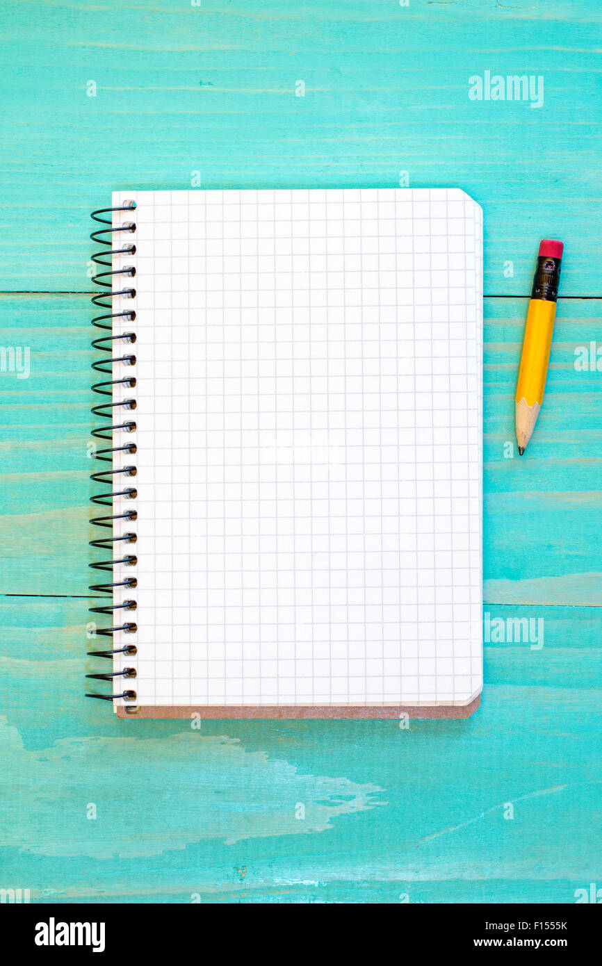 Open notebook and pencil on the blue wooden surface Stock Photo