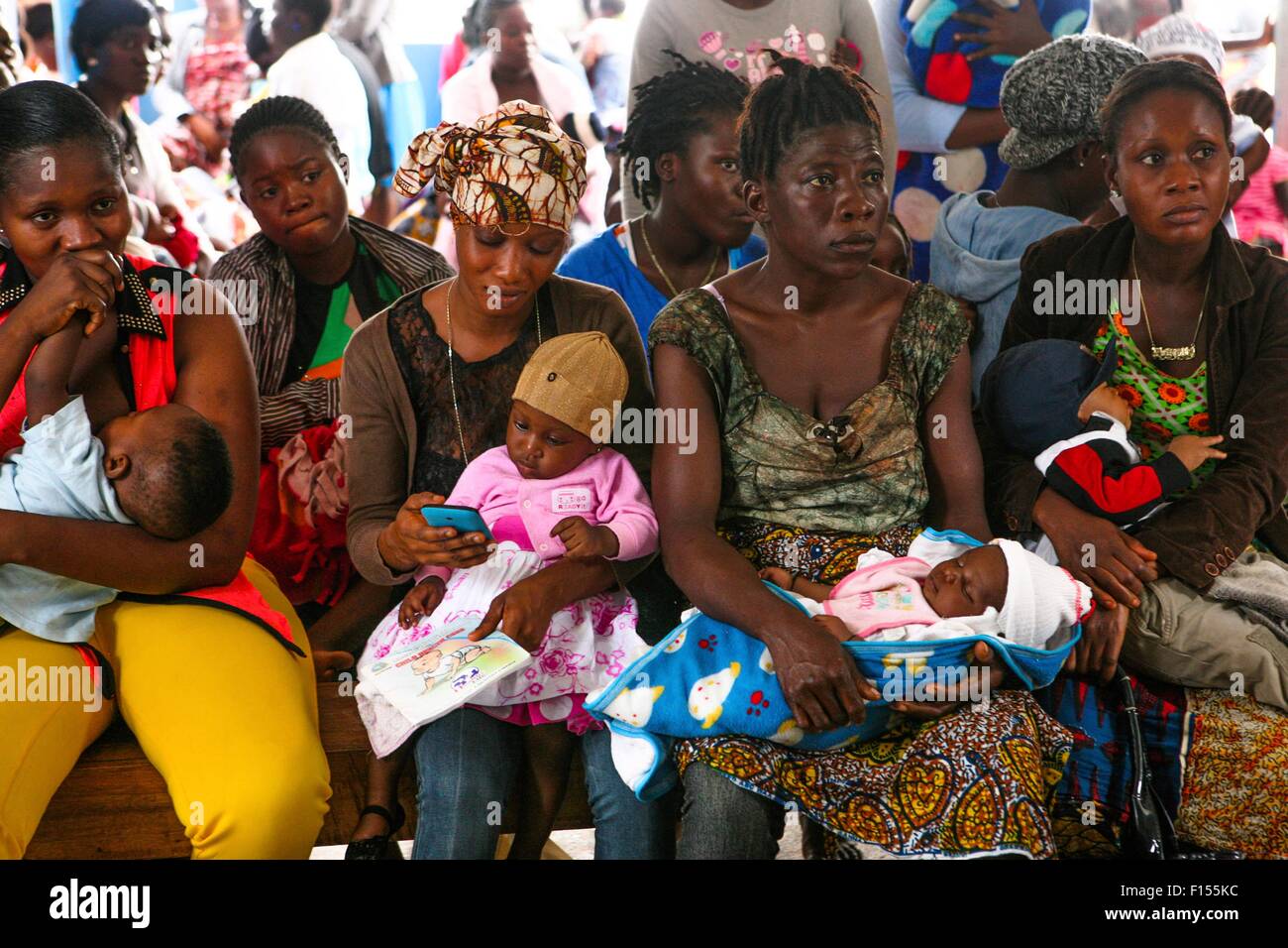 Liberian women wait with their children at a health clinic for a health check during the Ebola outbreak February 6, 2015 in Monrovia, Liberia. Stock Photo