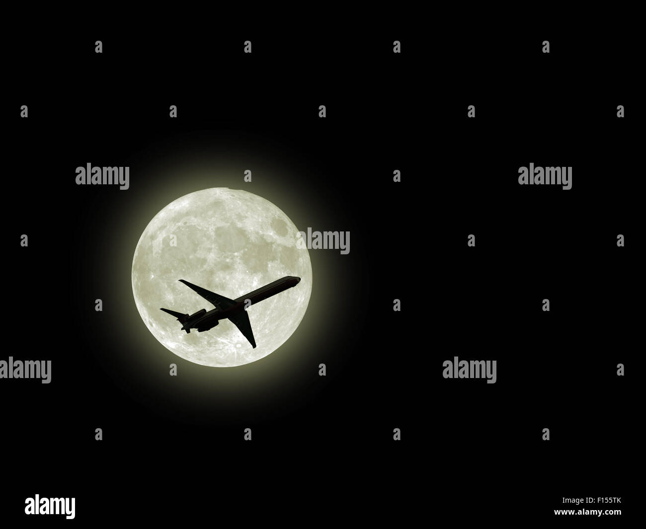an airplane flying across a full moon Stock Photo