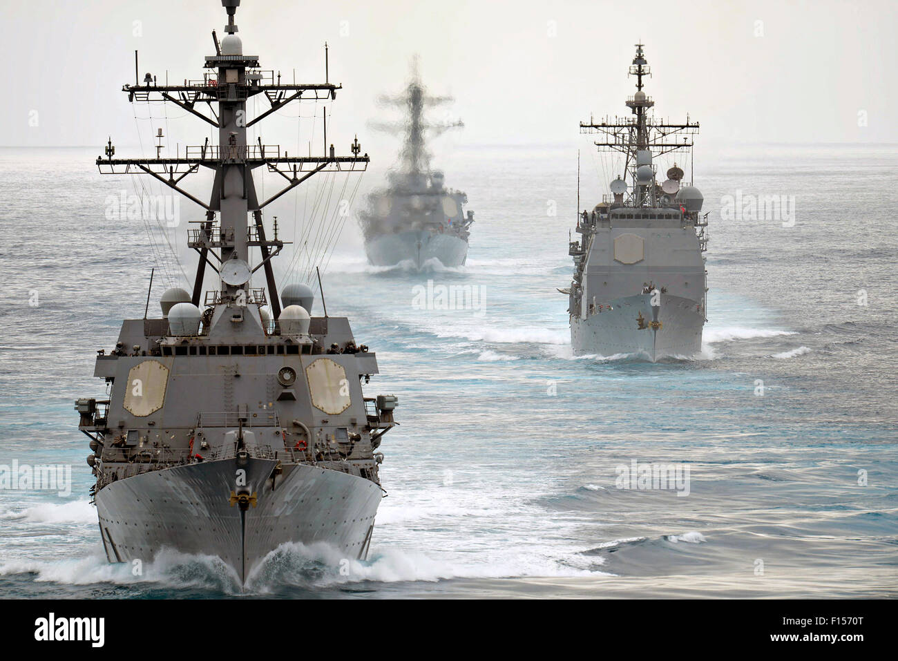 The U.S. Navy guided-missile destroyers USS Russel, USS Chung Hoon and the guided-missile cruiser USS Mobile Bay sail in formation during operations off the coast of San Clemente Island August 11, 2015 in the Pacific Ocean. Stock Photo