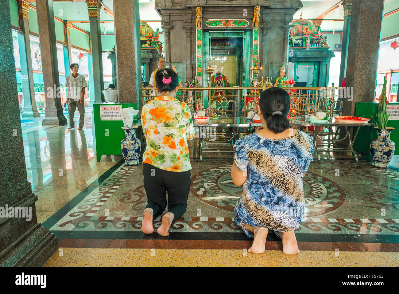 Women praying Vietnam, two women pray in the Mariamman Hindu temple in