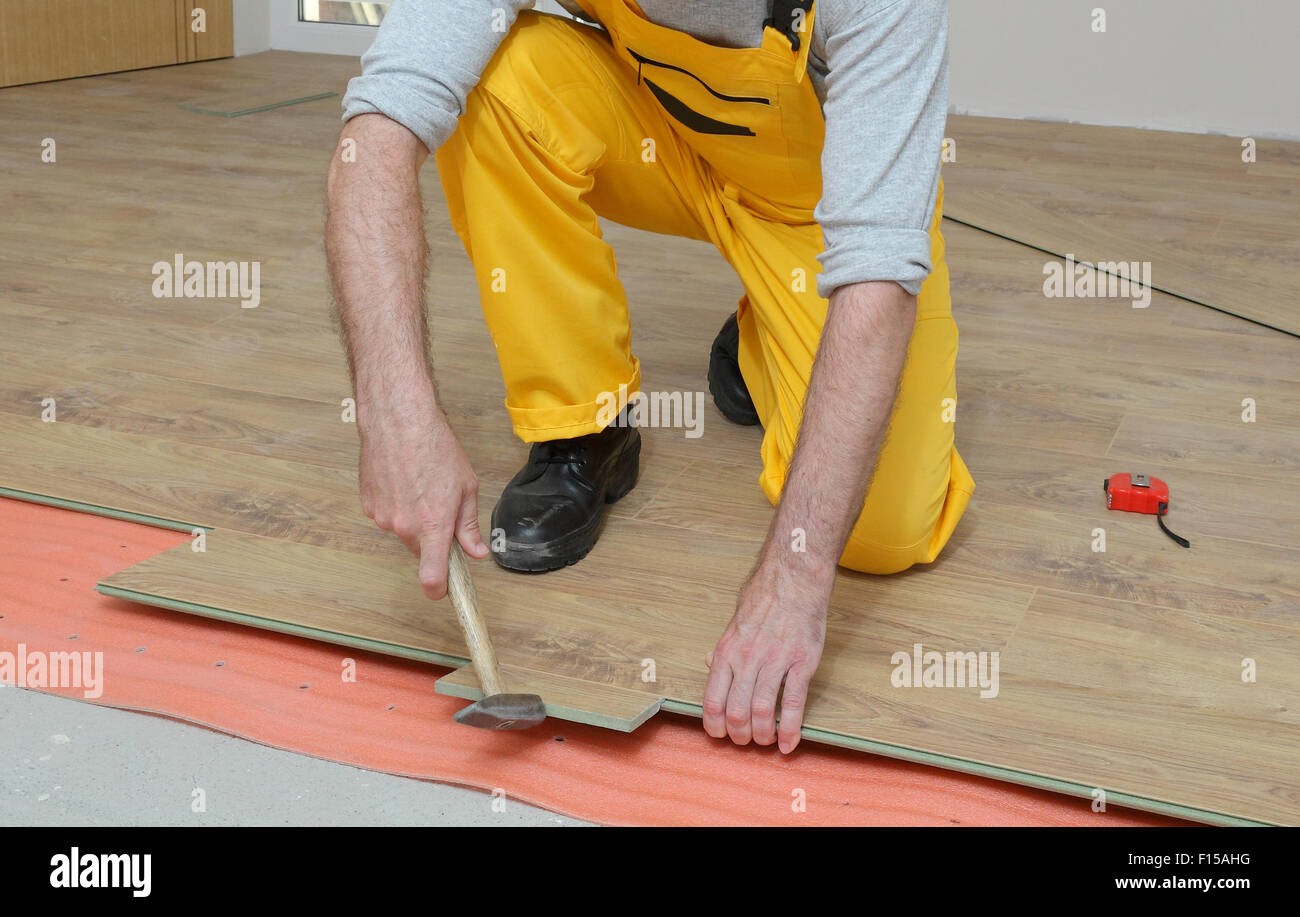 Adult Male Worker Installing Laminate Floor Floating Wood Tile