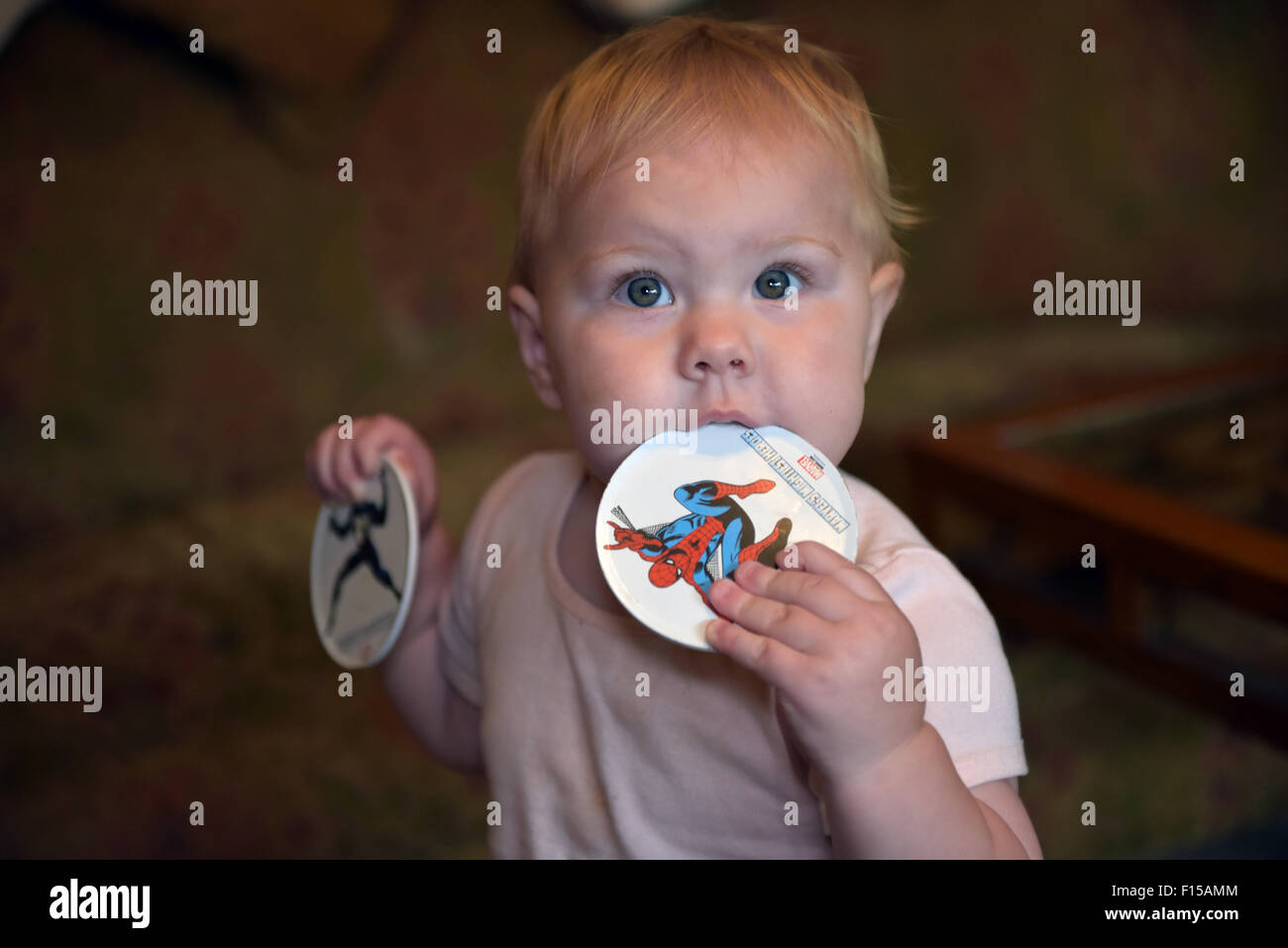 An eleven month old baby chewing on a plastic coaster to alleviate the pain and discomfort of tooth ache. Stock Photo