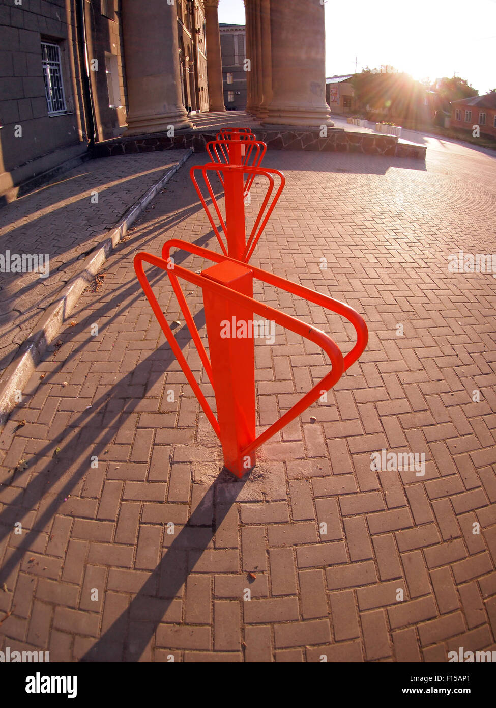 Parking for bicycles near the old building with columns on a background of the setting sun Stock Photo