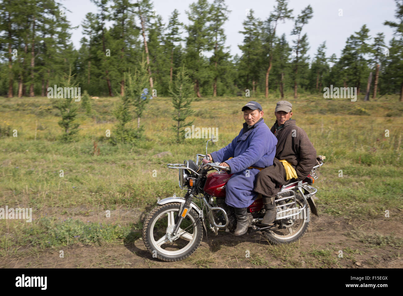 Mongolians on a motorcycle in Northern Mongolia. Stock Photo