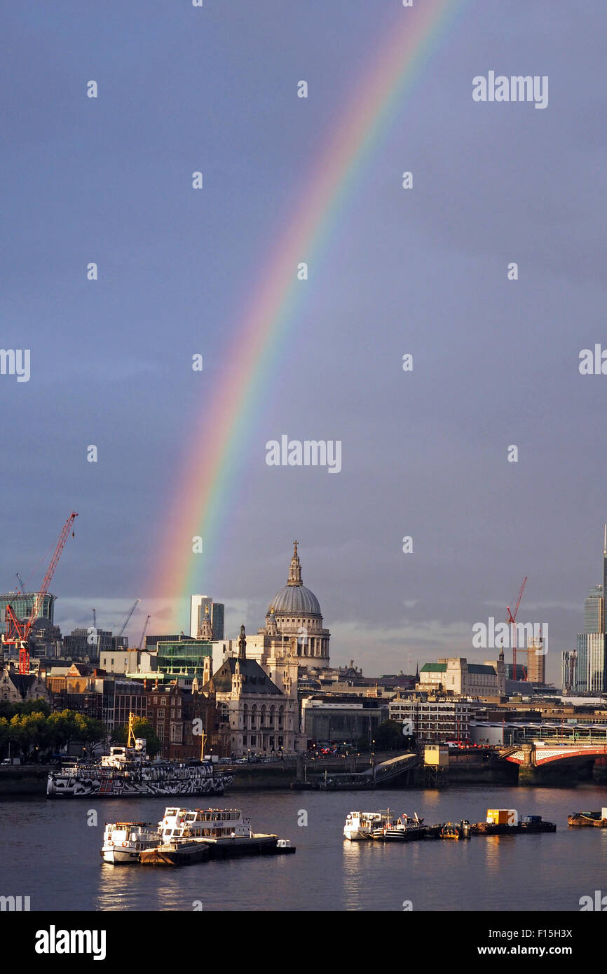 London, UK. 27th August 2015. Rainbow over the River Thames and City of London, England. A shower of rain just before sunset produced a beautiful rainbow stretching across the River Thames and the City of London including St. Paul's Cathedral. Stock Photo