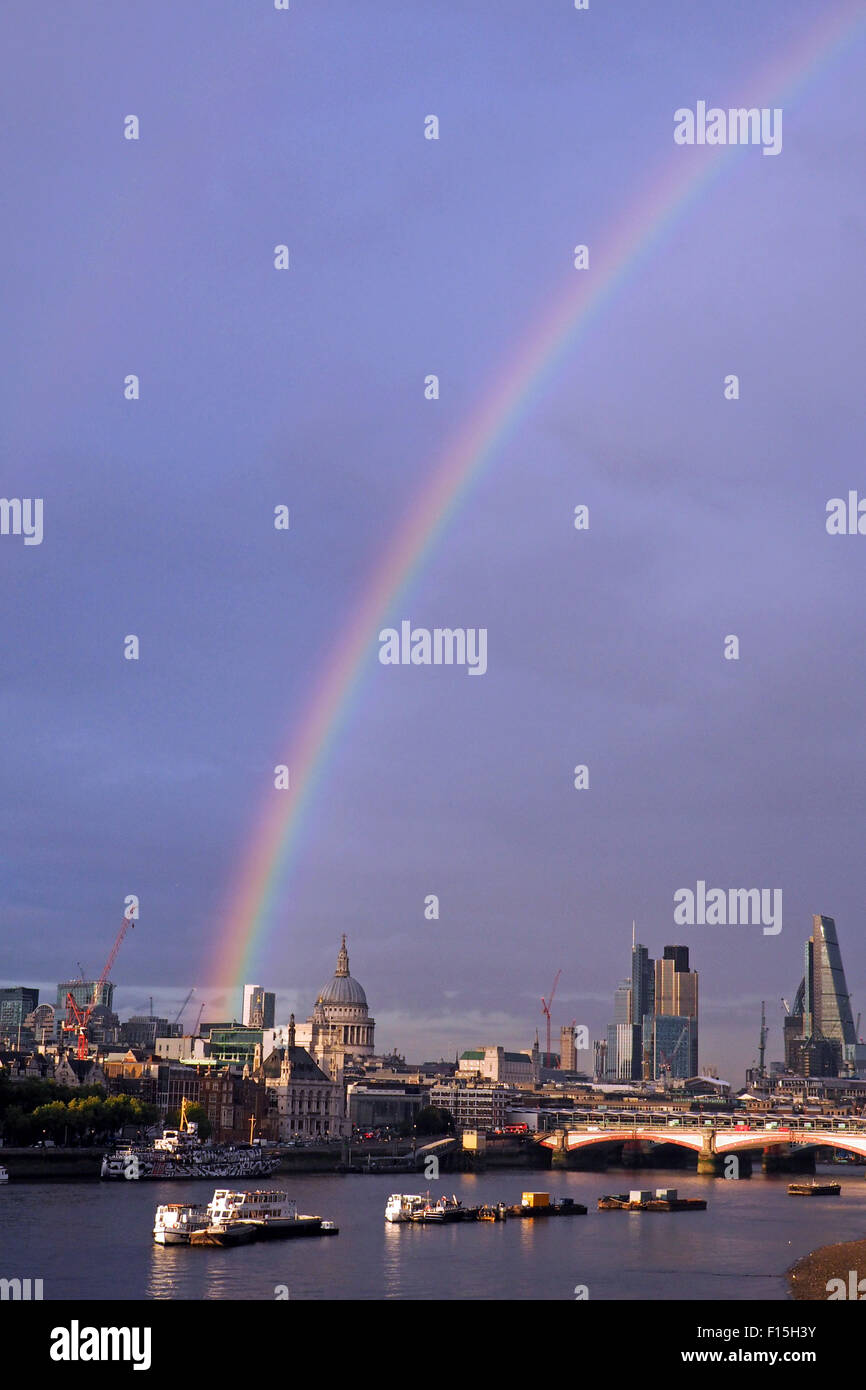 London, UK. 27th August 2015. Rainbow over the River Thames and City of London, England. A shower of rain just before sunset produced a beautiful rainbow stretching across the River Thames and the City of London including St. Paul's Cathedral. Stock Photo